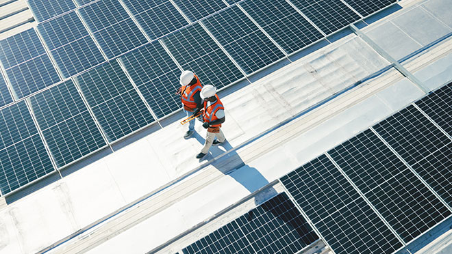 solar panels and team walking on roof planning for inspection
