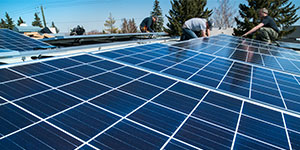 Workers installing solar panels on a residential homes roof.