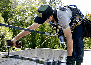 Contractor installing solar panels on roof