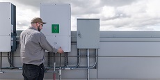 Photo of a man opening a panel on an energy storage system