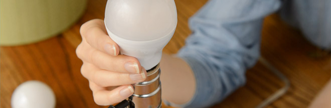 Woman changing LED lightbulb Woman changing LED lightbulb